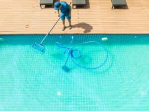 technician performing pool cleaning services
