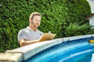 engineer inspecting a swimming pool during a maintenance visit